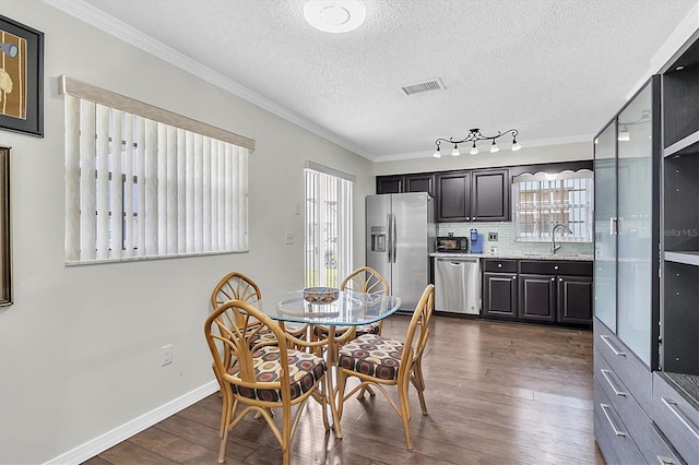 6219 Wilds Dr Unit 11A, New Port Richey, FL 34653 - dining space with healthy amount of natural light, dark wood-type flooring, ornamental molding, a textured ceiling, and baseboards