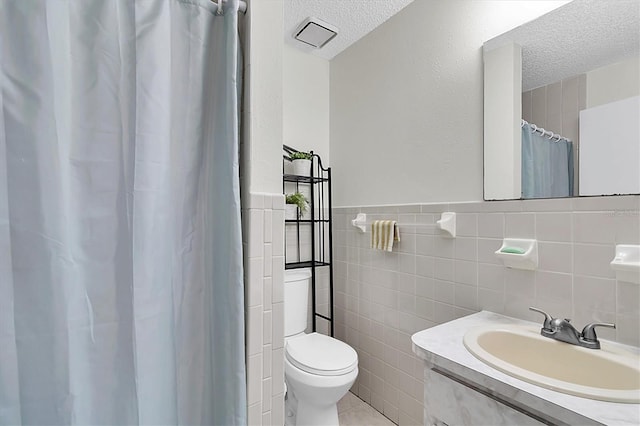 6219 Wilds Dr Unit 11A, New Port Richey, FL 34653 - bathroom with a textured ceiling, toilet, tile walls, vanity, and a shower with curtain