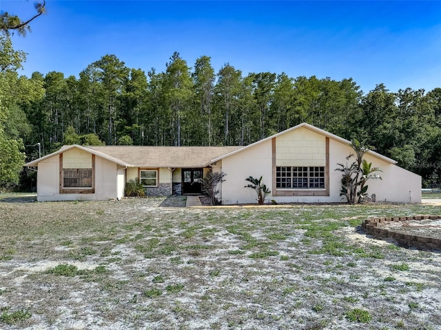 view of front of house with a wooded view