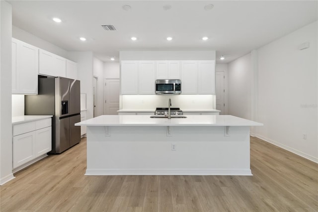 5240 Luisa Ct, Saint Cloud, FL 34771 - kitchen with stainless steel appliances, a center island with sink, white cabinets, light countertops, and recessed lighting