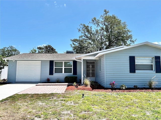 ranch-style home with driveway, a shingled roof, a front lawn, and a garage