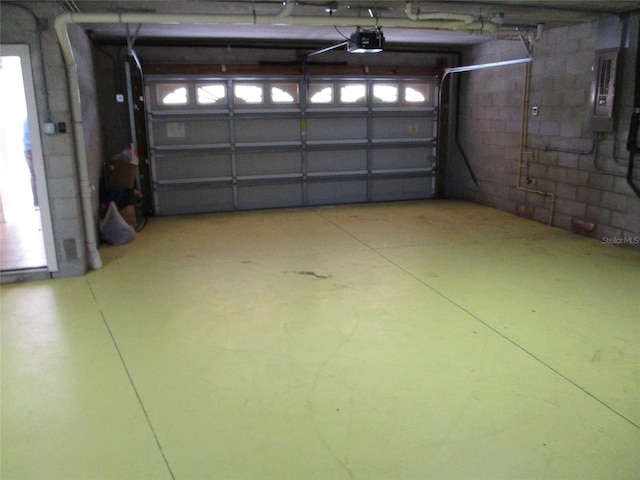 garage with concrete block wall and a garage door opener
