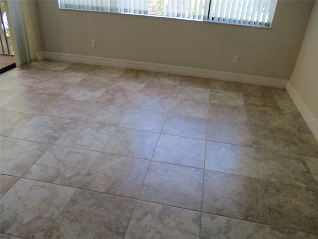 empty room featuring baseboards and a wealth of natural light