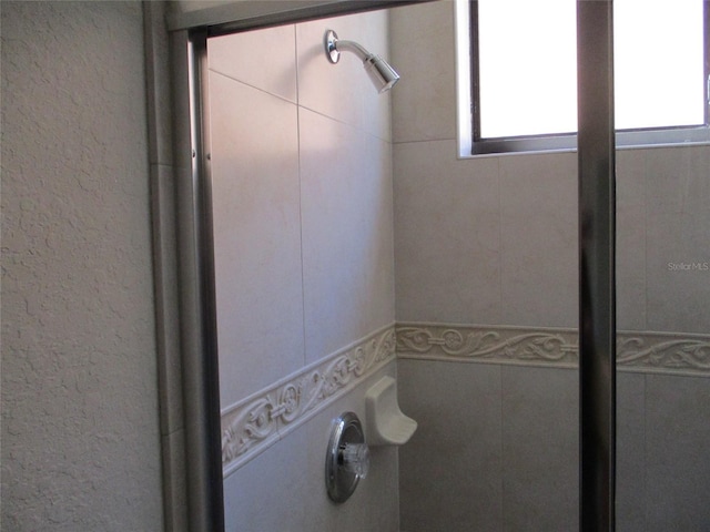 full bathroom featuring plenty of natural light and tiled shower