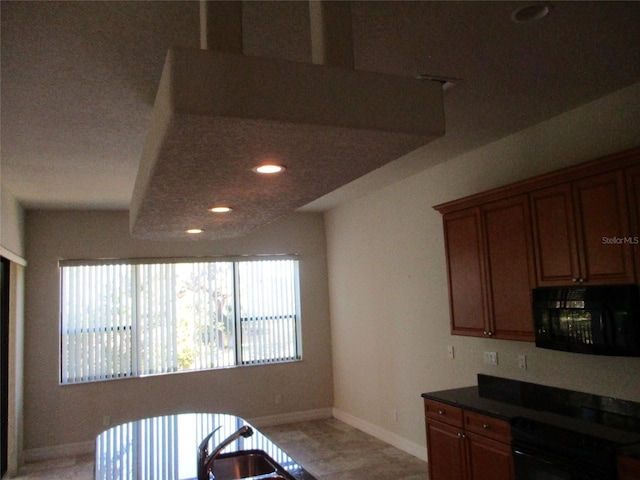 kitchen with brown cabinets, dark countertops, black microwave, stove, and baseboards