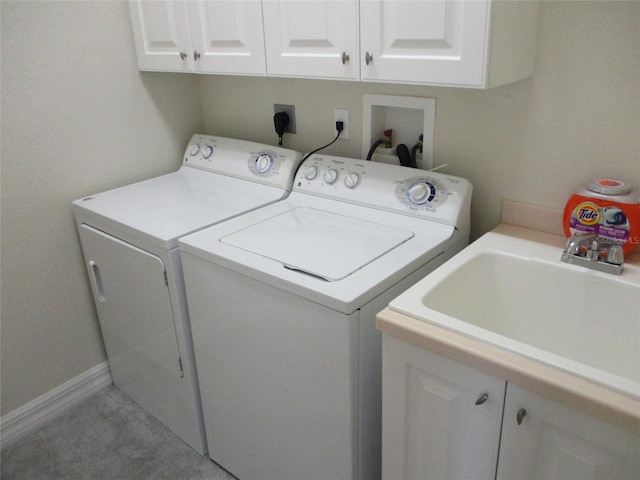 laundry area featuring separate washer and dryer, a sink, and cabinet space