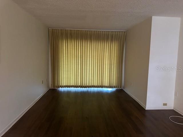 840 Virginia St Unit 202, Dunedin, FL 34698 - empty room with a textured ceiling, baseboards, and wood finished floors