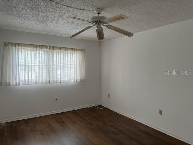 840 Virginia St Unit 202, Dunedin, FL 34698 - spare room with a textured ceiling, ceiling fan, and wood finished floors
