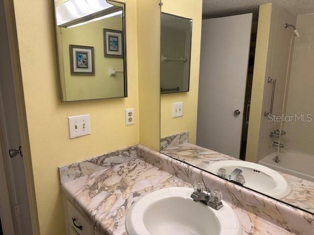 840 Virginia St Unit 202, Dunedin, FL 34698 - bathroom featuring a textured ceiling, bathing tub / shower combination, and vanity