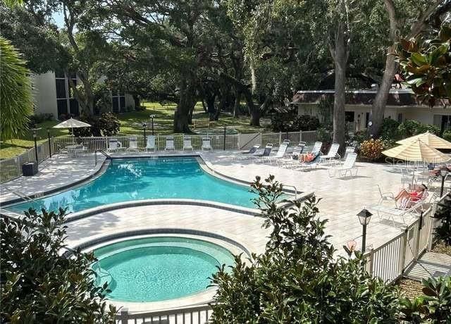 840 Virginia St Unit 202, Dunedin, FL 34698 - pool with a hot tub, fence, and a patio area