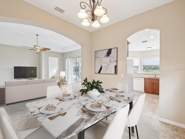 dining room featuring arched walkways, light tile patterned floors, and visible vents