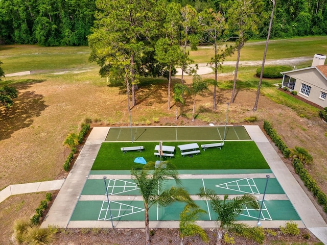 view of community with a yard and shuffleboard