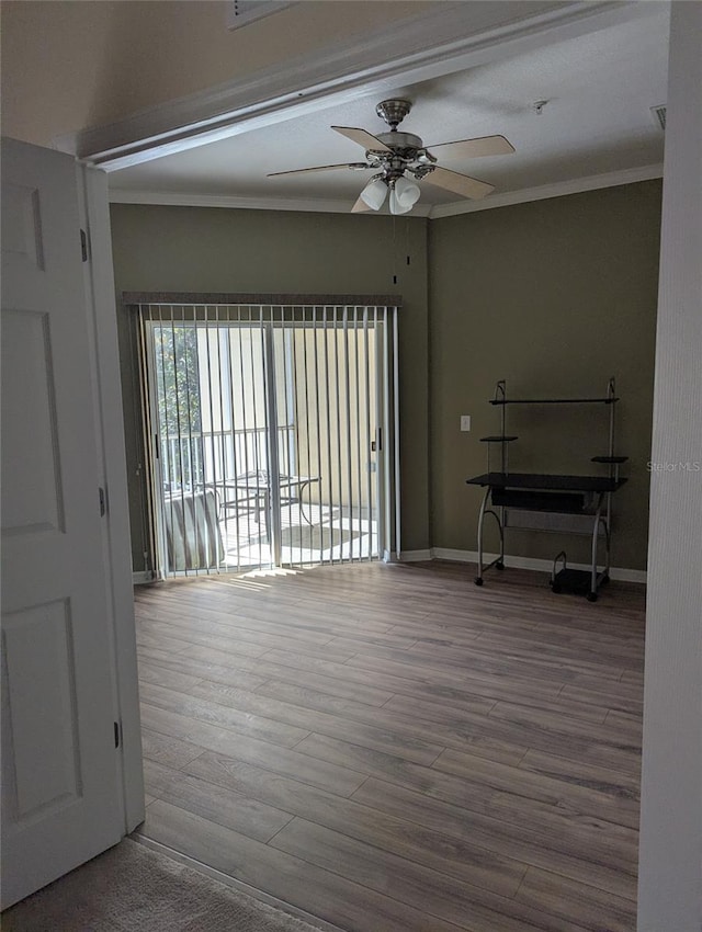 21008 Sunpoint Way Unit 204, Lutz, FL 33558 - spare room with crown molding, baseboards, a ceiling fan, and wood finished floors