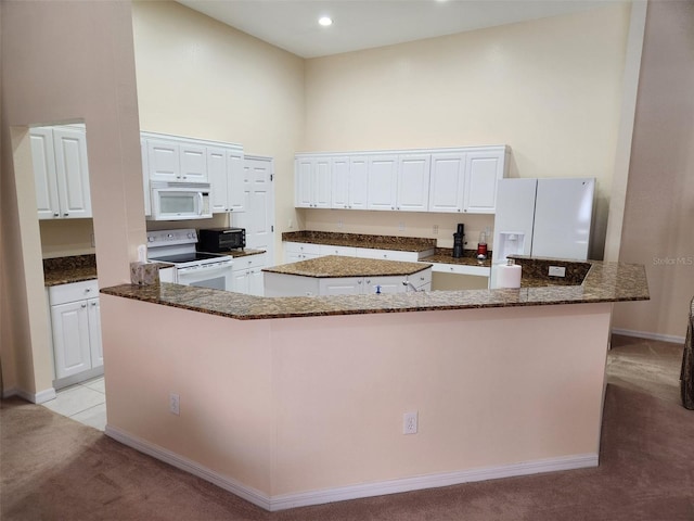 21008 Sunpoint Way Unit 204, Lutz, FL 33558 - kitchen with light carpet, white appliances, a center island, white cabinetry, and a towering ceiling