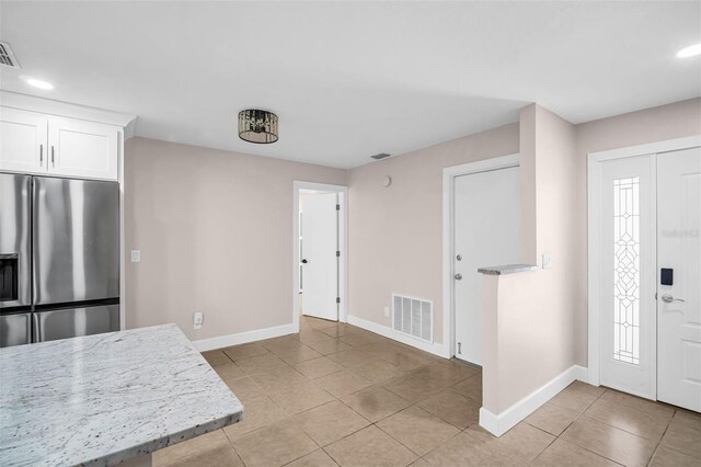 2660 Orangewood Ct, Palm Harbor, FL 34684 - kitchen featuring stainless steel refrigerator with ice dispenser, baseboards, light tile patterned flooring, and visible vents
