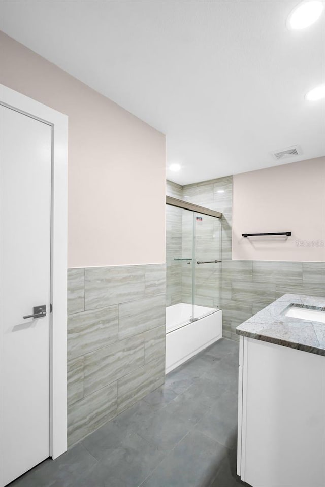 2660 Orangewood Ct, Palm Harbor, FL 34684 - bathroom with visible vents, tile walls, wainscoting, vanity, and recessed lighting