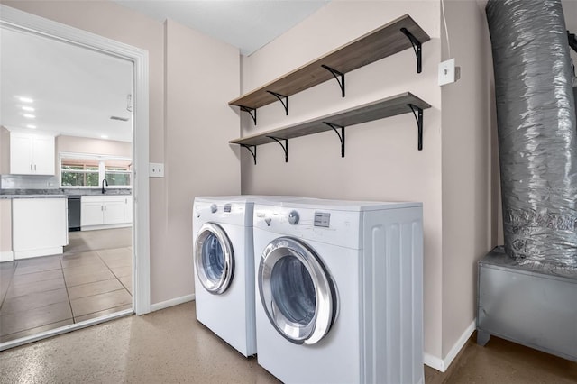 2660 Orangewood Ct, Palm Harbor, FL 34684 - laundry area with baseboards, washer and clothes dryer, a sink, and laundry area