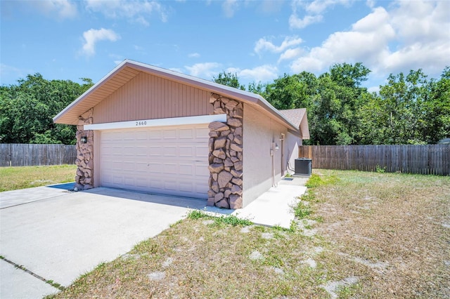 2660 Orangewood Ct, Palm Harbor, FL 34684 - garage with fence, cooling unit, and driveway