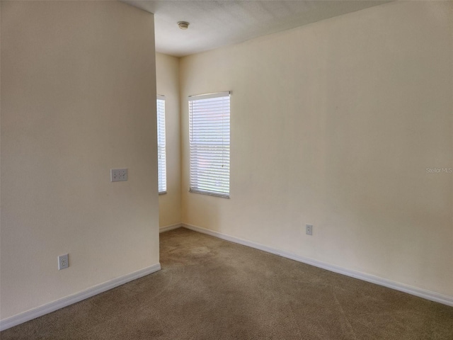 carpeted empty room with baseboards