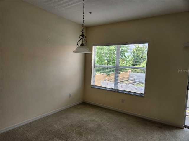 carpeted spare room featuring baseboards