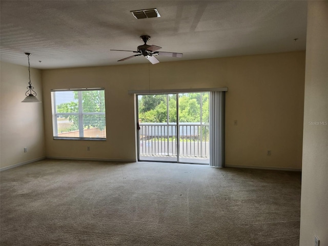 spare room featuring baseboards, ceiling fan, carpet flooring, and visible vents