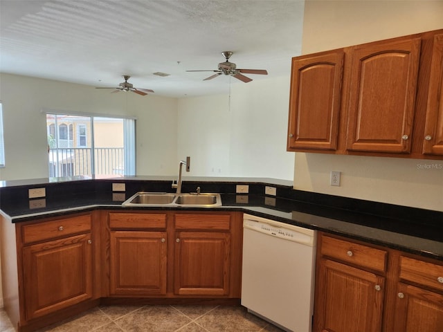 kitchen with a peninsula, brown cabinetry, a sink, and dishwasher