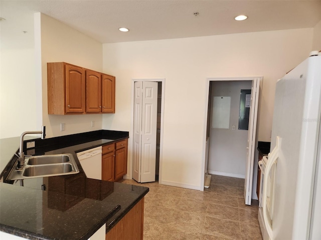 kitchen with brown cabinetry, a sink, a peninsula, recessed lighting, and white appliances