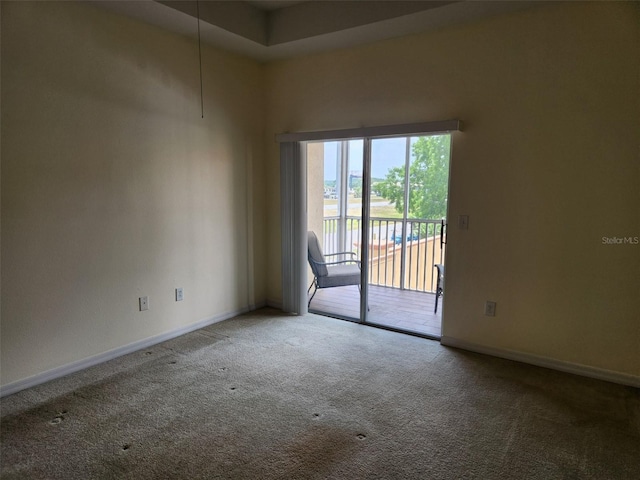 unfurnished room featuring carpet floors and baseboards