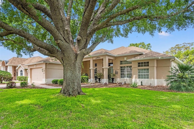 view of front of home featuring a garage, a front lawn, and stucco siding