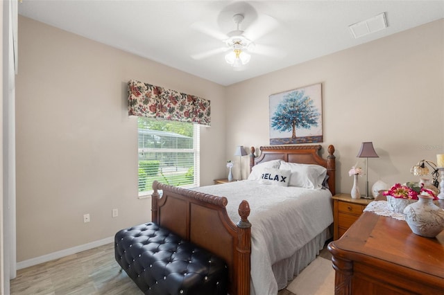 bedroom with baseboards, a ceiling fan, light wood-style flooring, and visible vents