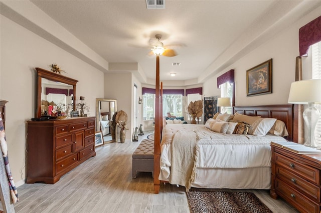 bedroom with visible vents, a ceiling fan, and light wood-style floors