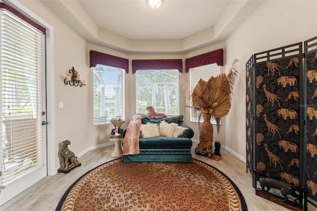 sitting room featuring baseboards and light wood-type flooring