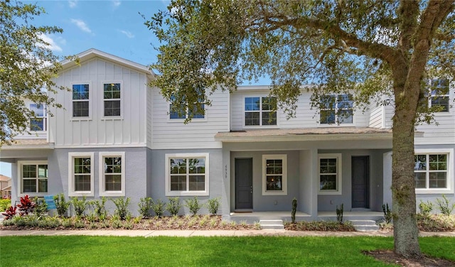 3307 Grande Heron Dr, Saint Cloud, FL 34773 - view of front of home with a front lawn, board and batten siding, roof with shingles, and covered porch
