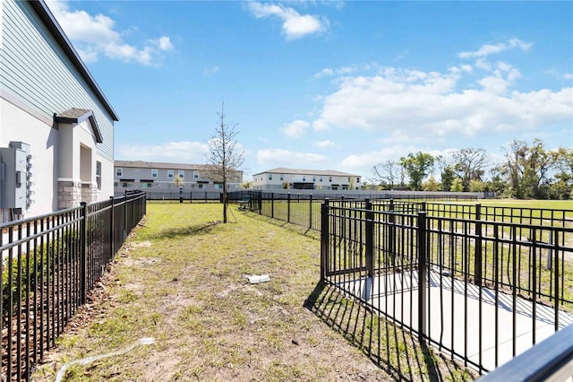 view of yard featuring fence and a residential view