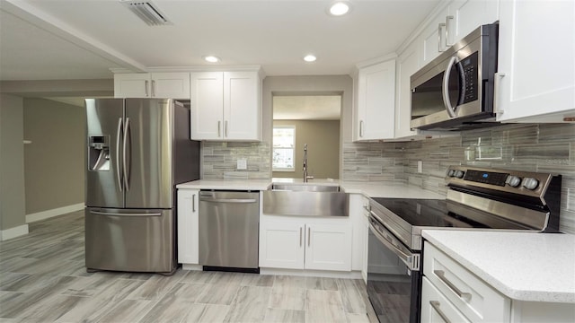 8522 Inwood Dr, Hudson, FL 34667 - kitchen with a sink, stainless steel appliances, white cabinetry, recessed lighting, and visible vents
