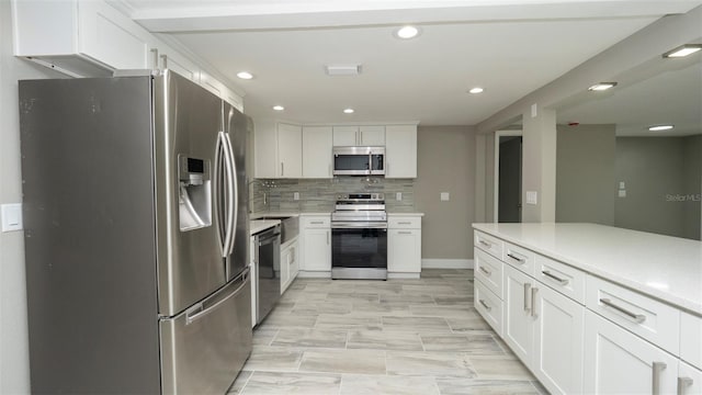8522 Inwood Dr, Hudson, FL 34667 - kitchen featuring recessed lighting, light countertops, white cabinetry, a sink, and appliances with stainless steel finishes
