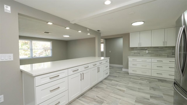 8522 Inwood Dr, Hudson, FL 34667 - kitchen featuring light countertops, white cabinets, freestanding refrigerator, and tasteful backsplash