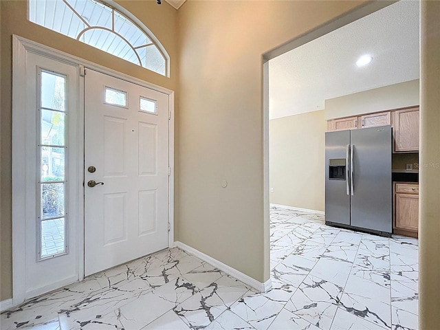 entryway with light marble finish flooring, baseboards, and recessed lighting