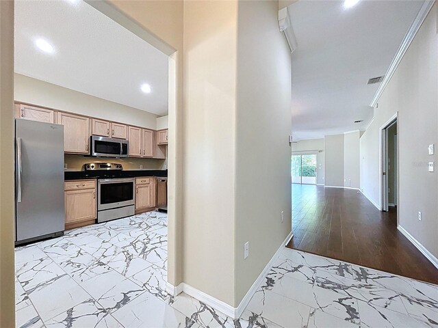 kitchen featuring appliances with stainless steel finishes, light marble finish flooring, dark countertops, baseboards, and recessed lighting