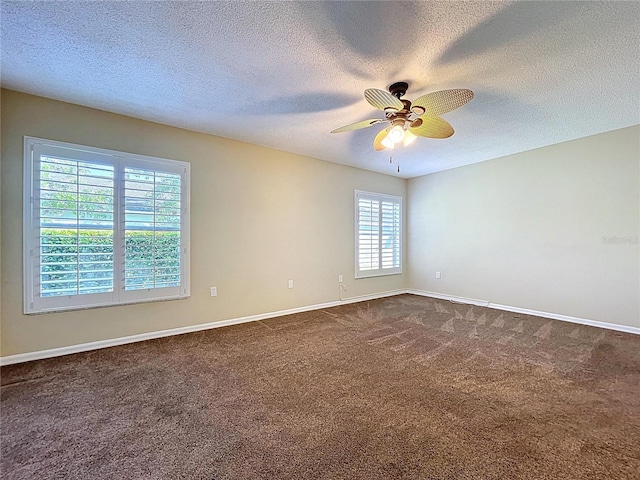 unfurnished room featuring a textured ceiling, a ceiling fan, dark colored carpet, and baseboards