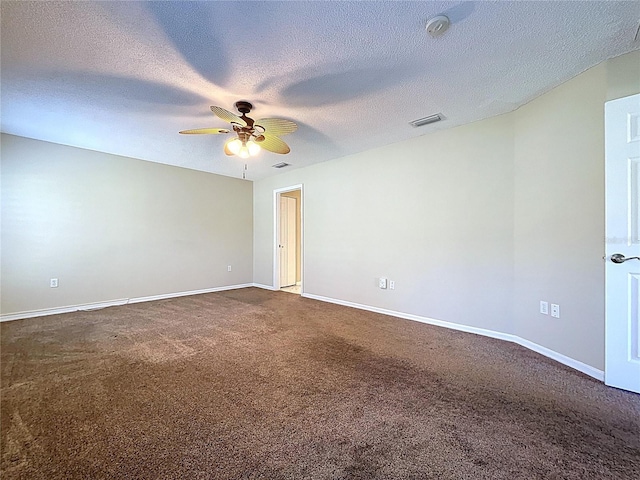 empty room featuring dark carpet, a ceiling fan, baseboards, and a textured ceiling