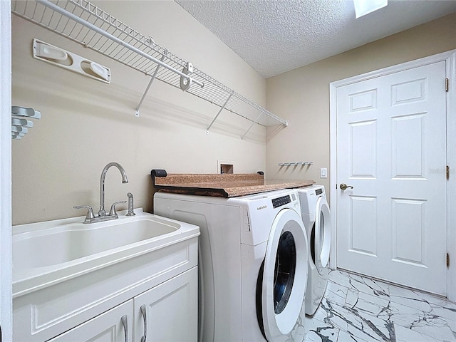 laundry room featuring washer and clothes dryer, light marble finish flooring, cabinet space, and a textured ceiling