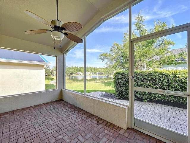 unfurnished sunroom featuring a water view and ceiling fan