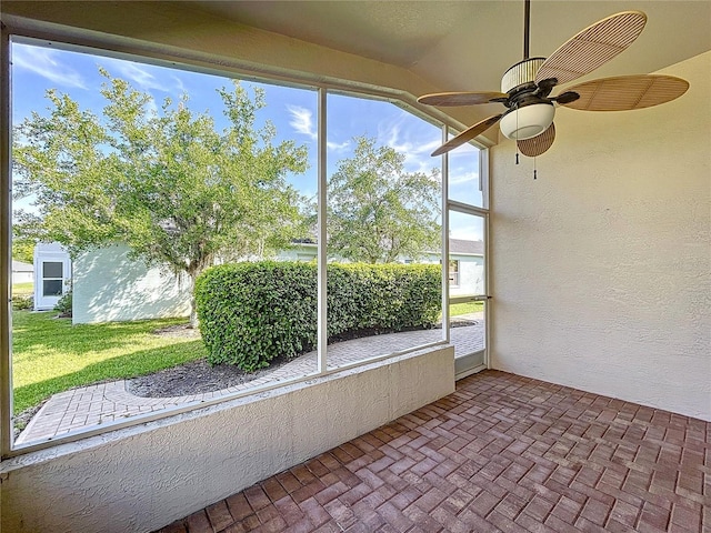 unfurnished sunroom featuring ceiling fan