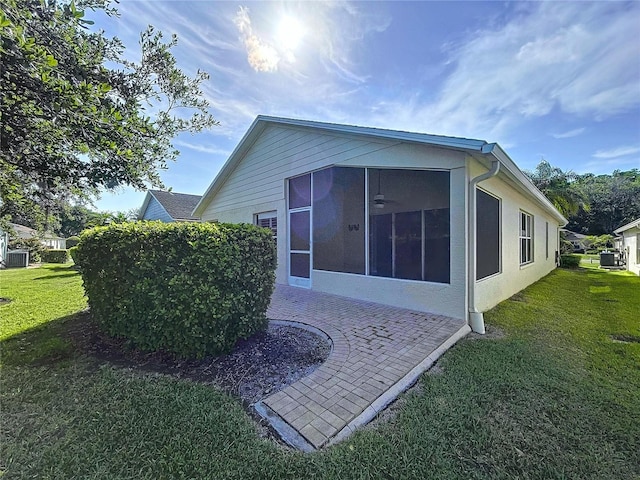 back of house with a yard, a sunroom, and central AC unit