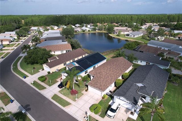aerial view of residential area with a forest and a nearby body of water