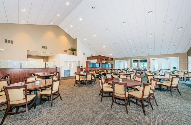 carpeted dining area featuring high vaulted ceiling and recessed lighting