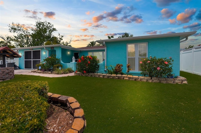 exterior space with fence, stucco siding, and a front yard