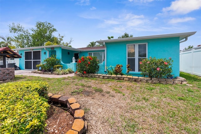 single story home featuring fence and a front lawn
