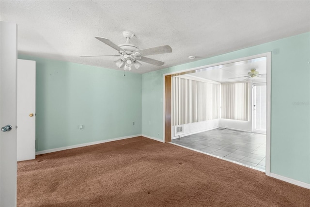 carpeted empty room featuring baseboards, a textured ceiling, ceiling fan, and visible vents